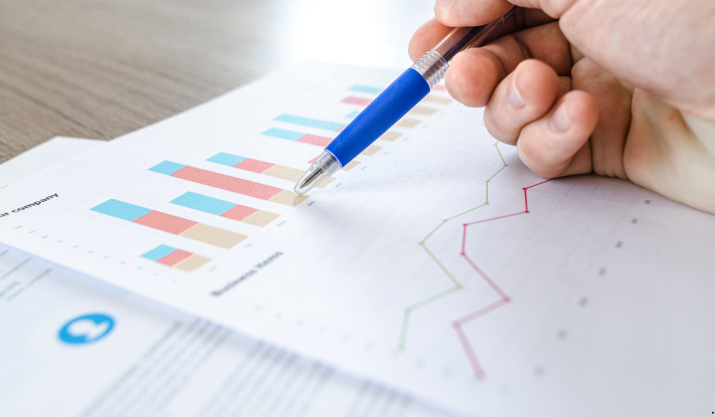 Analyst examining bar and line charts, illustrating how Statistical Analysis for Six Sigma uses graphical analysis and statistical data to identify trends, variation, and improvement opportunities.