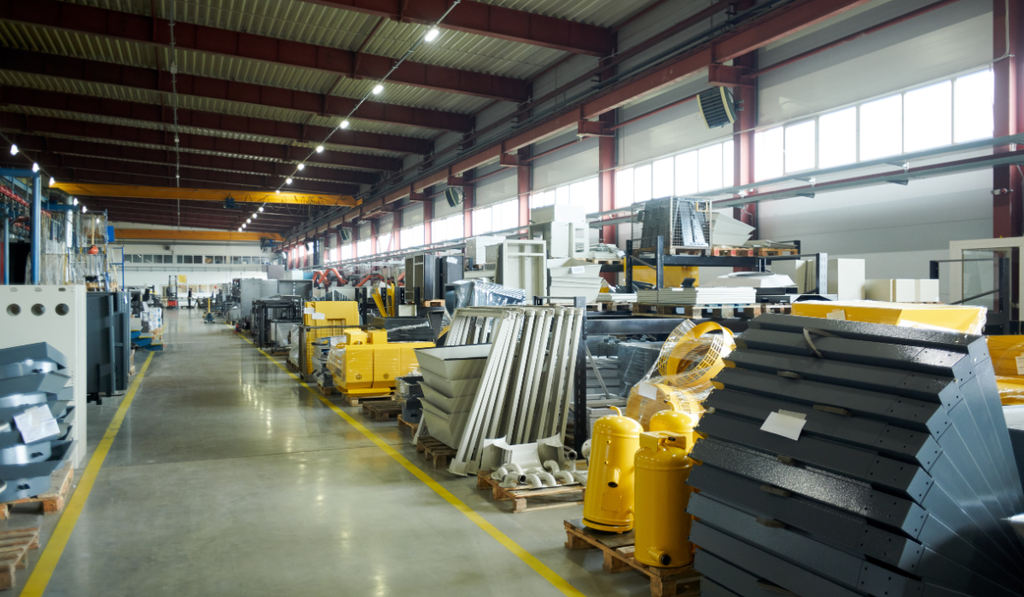 Factory floor with staged components and materials, illustrating how a pull system in Lean manufacturing controls inventory and replenishment based on consumption.