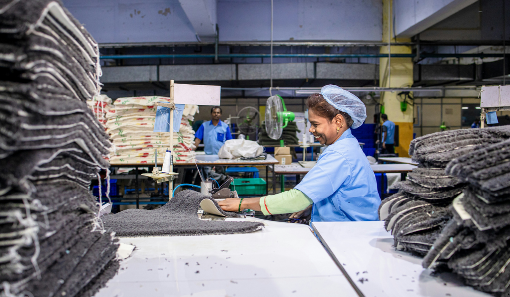 Factory operator processing materials at a workstation, illustrating how cycle time is measured against takt time to evaluate production pace.