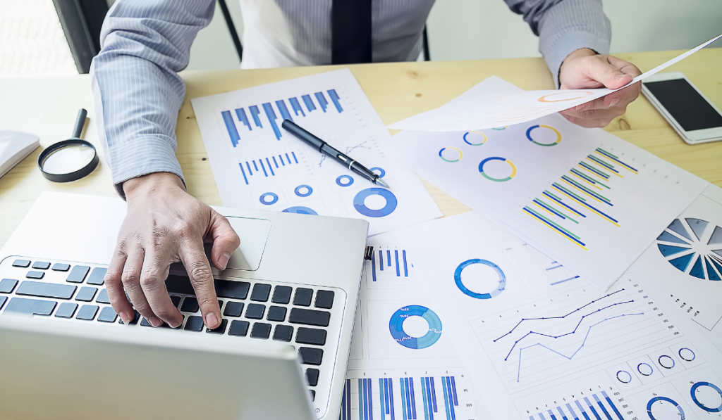 Analyst examining charts and performance data on a laptop as part of the Measure and Analyze stages of the DMAIC process.
