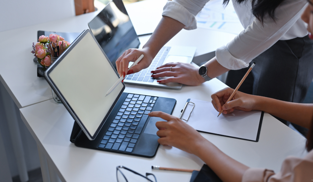 Business professionals working together on laptops and documents to support Lean Six Sigma process improvement and problem-solving.