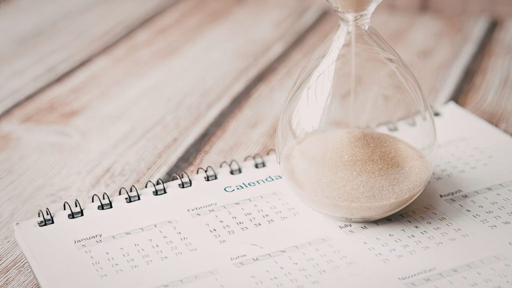 Hourglass on a calendar illustrating time management and deadline planning with a Task Prioritization Matrix.