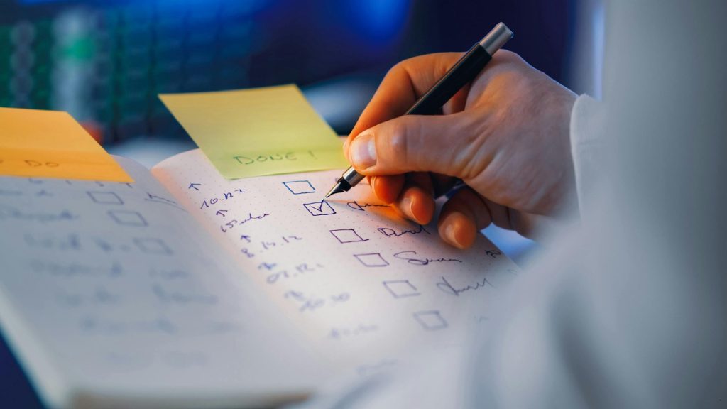 Professional checking a to-do list while applying a Task Prioritization Matrix to manage tasks and improve productivity.