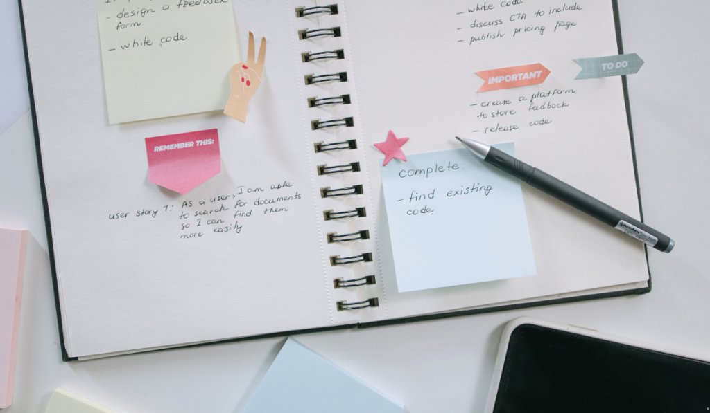 Open notebook with sticky notes and handwritten tasks illustrating WSJF prioritization and work planning.