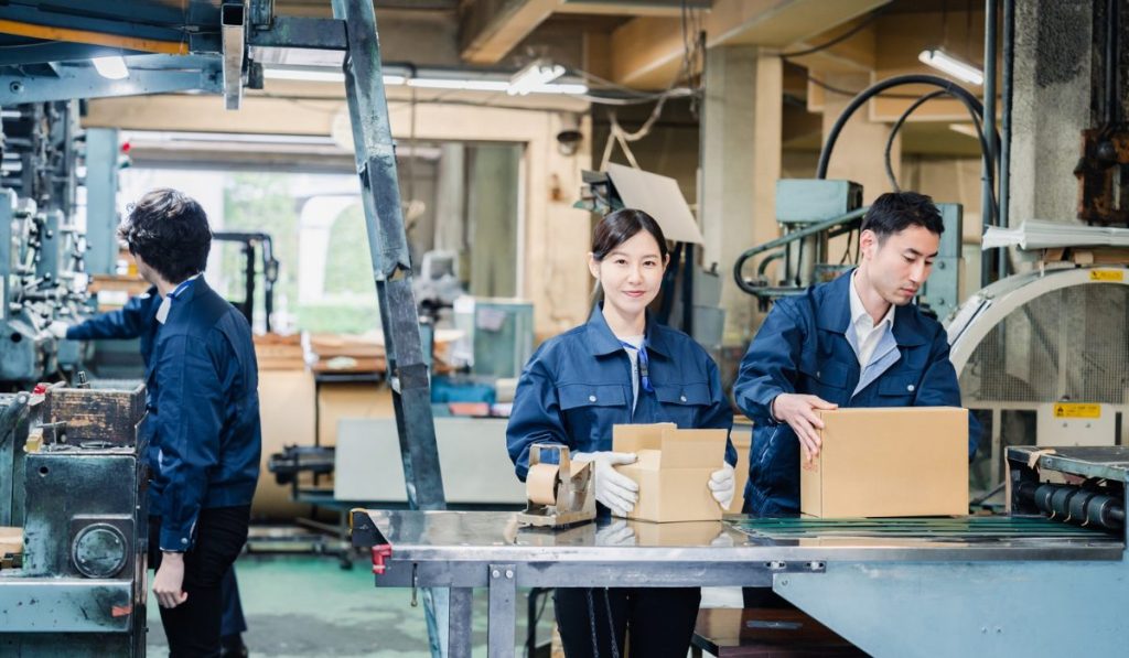 Production workers packaging products in a manufacturing facility where CPK process capability helps ensure consistent quality control.
