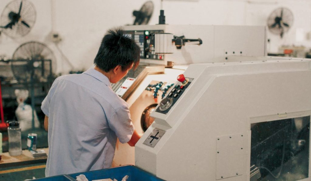 Manufacturing technician operating industrial equipment to monitor CPK process capability and maintain production quality standards.