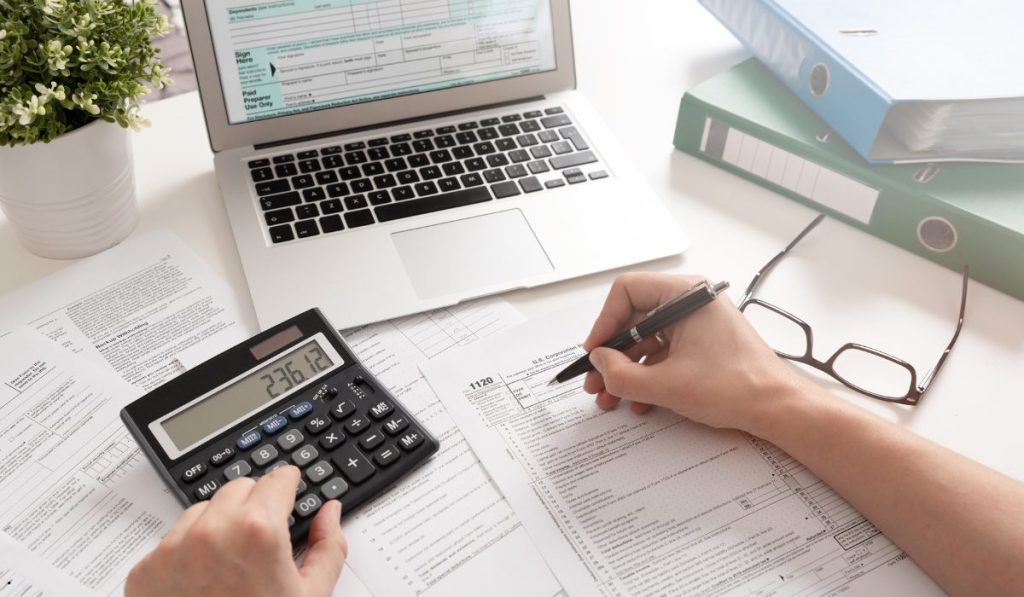 Professional calculating financial projections using expected monetary value to assess costs, risks, and potential outcomes.