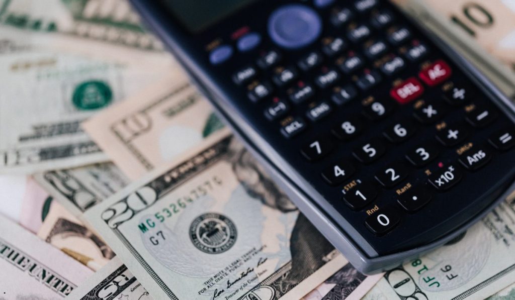 Calculator and currency representing expected monetary value calculations for financial planning and decision-making.
