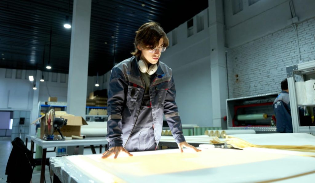 Manufacturing engineer inspecting production quality during a Rolled Throughput Yield evaluation to identify process improvements.