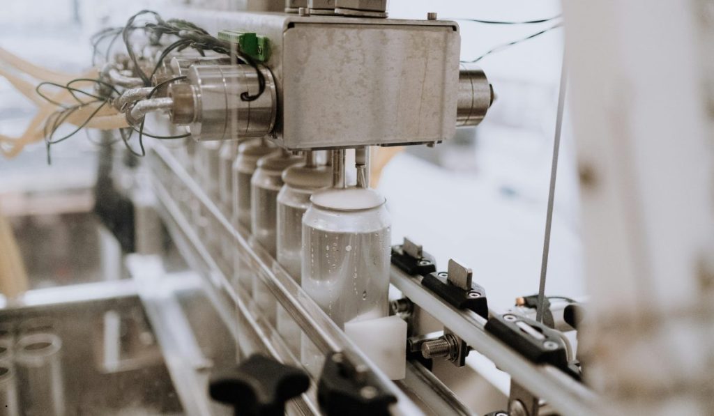 Automated production line filling containers during a Rolled Throughput Yield process to improve manufacturing quality and reduce defects.