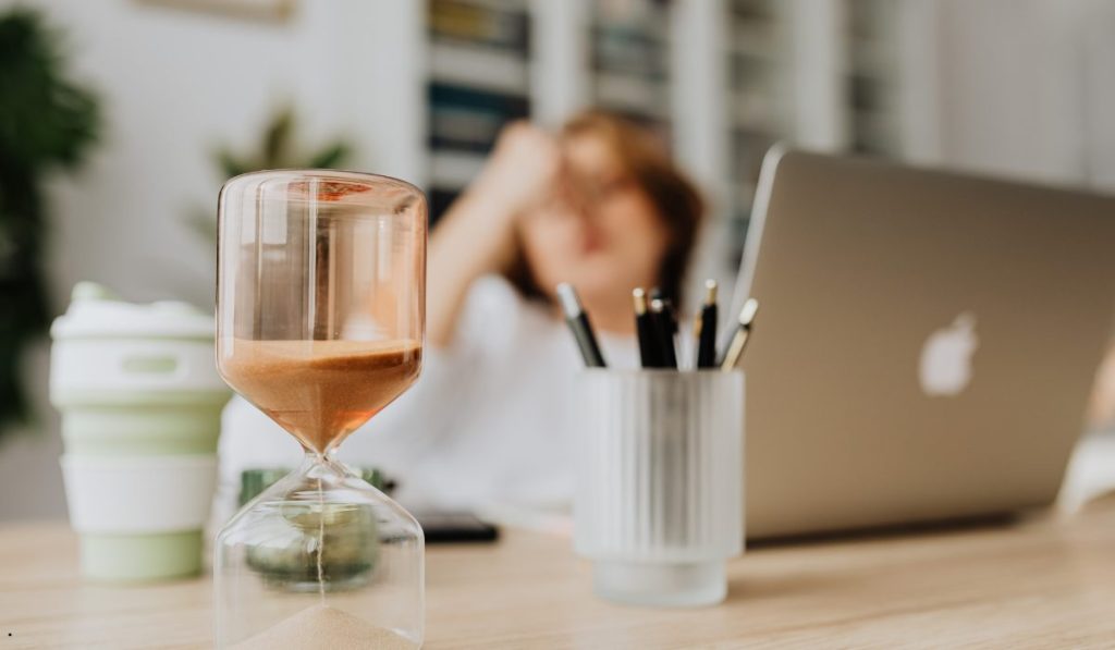 Hourglass on a desk illustrating turnaround time and the importance of completing tasks within expected timelines.