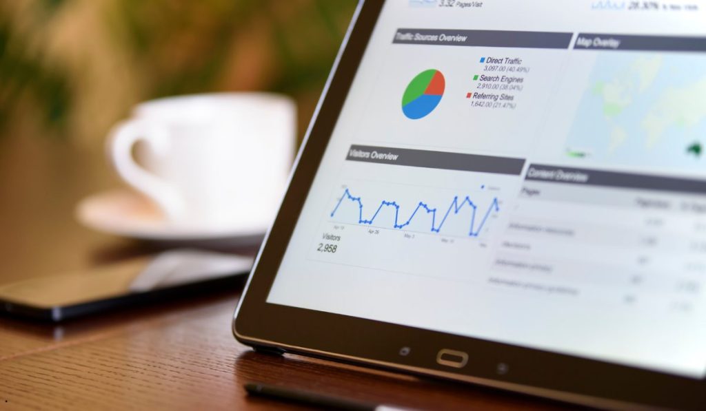Tablet displaying website analytics charts and traffic data used to identify a lurking variable in business performance analysis.