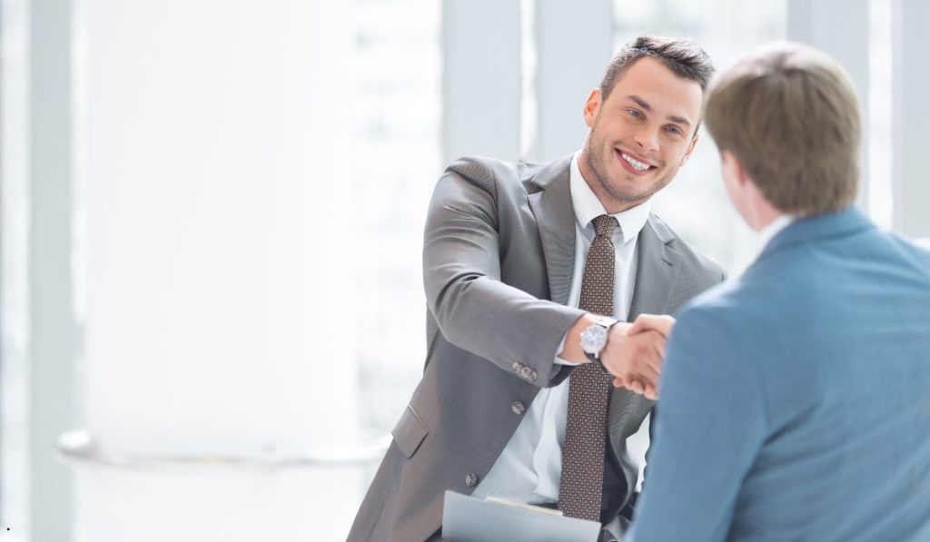 Business professionals shaking hands after successfully implementing an OCAP (Out of Control Action Plan) to resolve a quality issue.