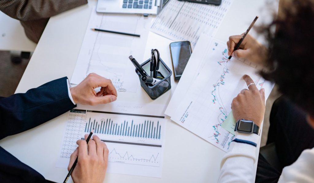 Analysts reviewing financial charts to understand and apply the Sample Mean Symbol in statistical analysis.