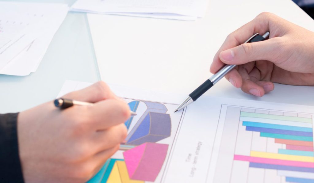 Business professionals reviewing colorful charts and graphs as part of Statistical Process analysis and performance evaluation.
