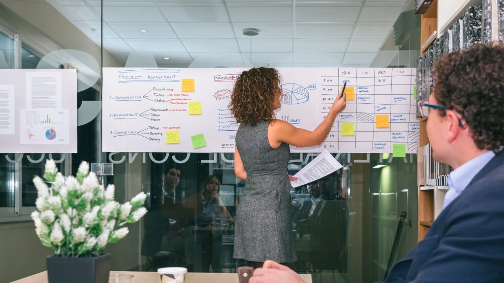 Business team reviewing schedules, timelines, and resource allocation during an Agile vs traditional project management strategy meeting.