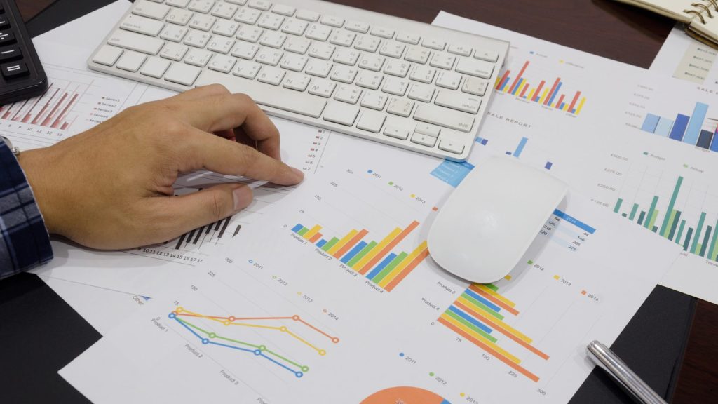 Business analyst reviewing charts and performance metrics to apply Deming’s 14 Points of Quality Management for continuous improvement.