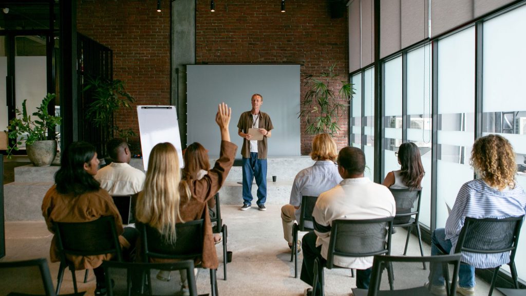 Knowledge Management Training seminar with participants engaging in collaborative learning and knowledge-sharing discussions in a professional classroom setting.