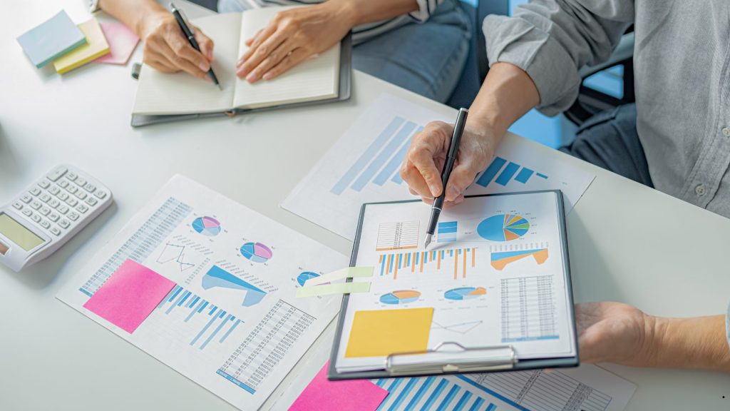 Project management course participants reviewing project performance reports, budgets, and data analytics to support effective project decision-making.