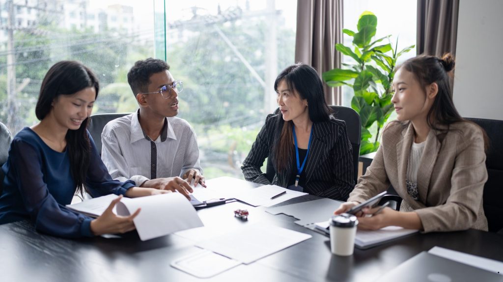Professionals discussing workforce allocation and resource utilization during a capacity planning in operations management meeting.