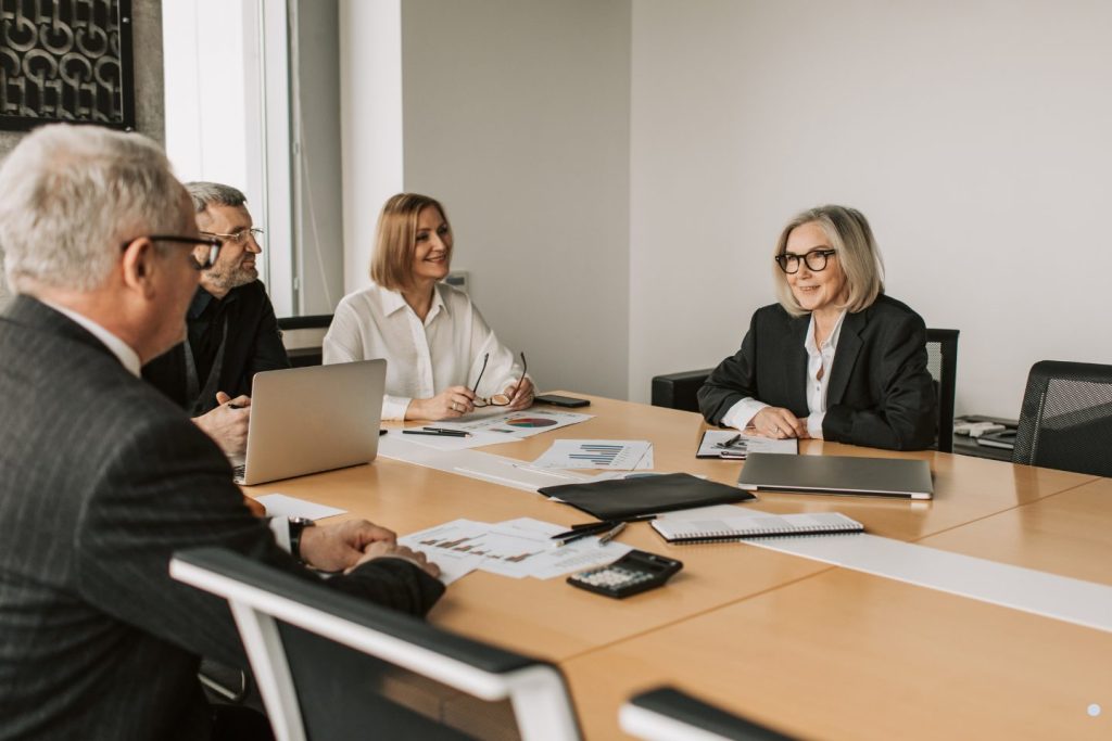 Executive team discussing reports and approval processes during a Change Control Board decision-making and governance session.