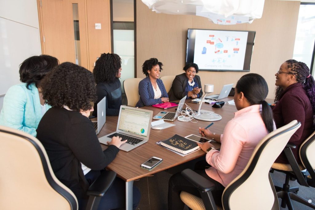 Business professionals collaborating in a Change Control Board meeting to review project updates, risks, and organizational changes.