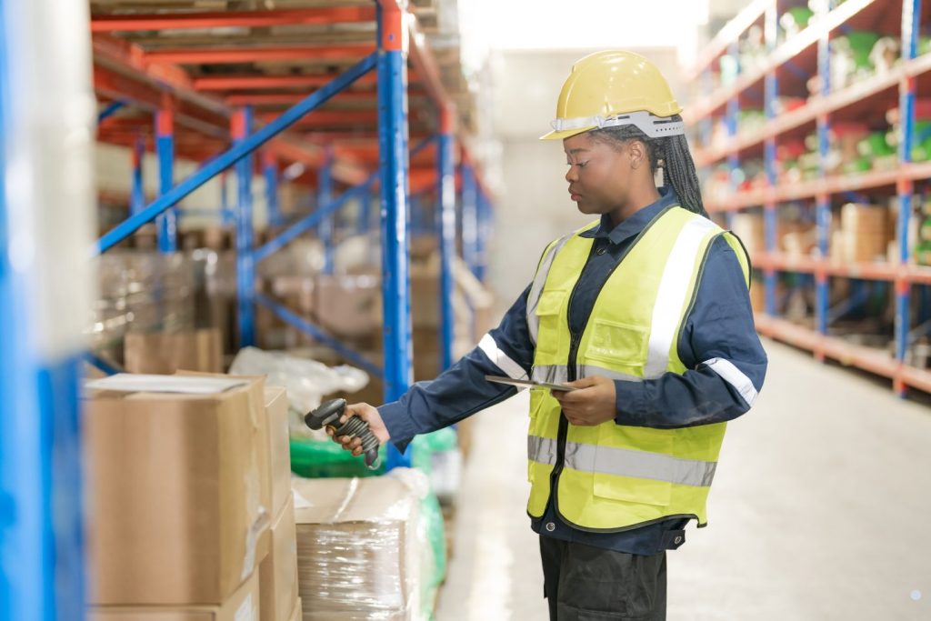 Warehouse employee scanning inventory in a distribution center as part of a Continuous Quality Improvement process for inventory accuracy and operational performance.