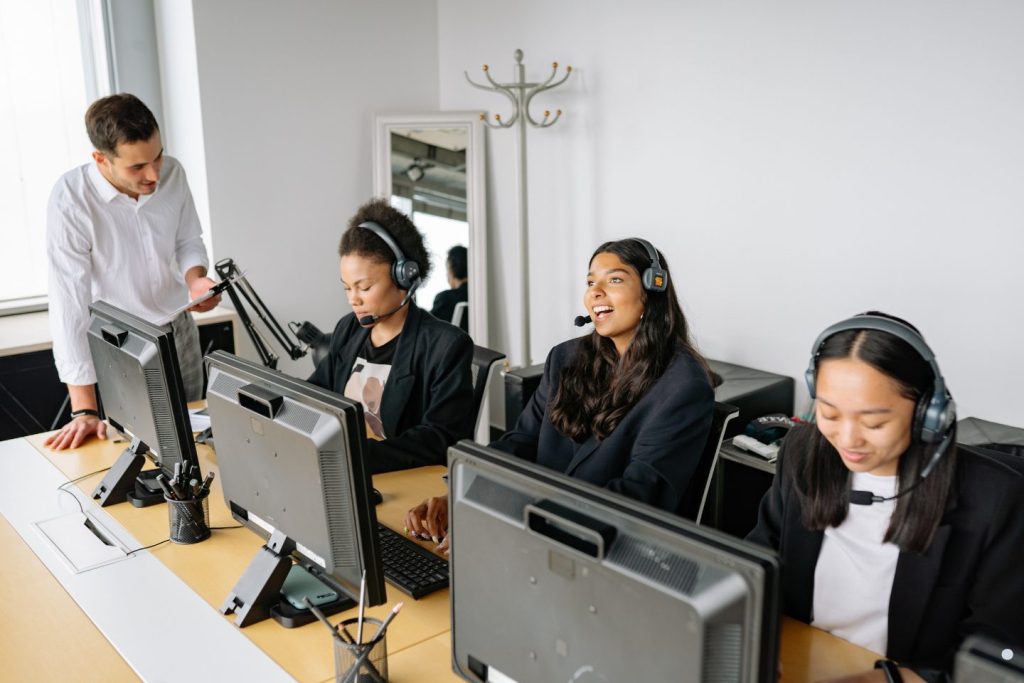 Customer service team using headsets and computers during a Continuous Quality Improvement training session focused on communication and workflow efficiency.