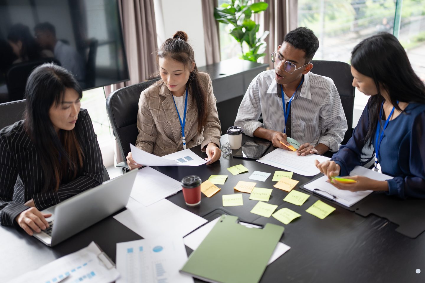 Team members discussing documents and brainstorming ideas during a Phases of Project Management strategy and collaboration session.