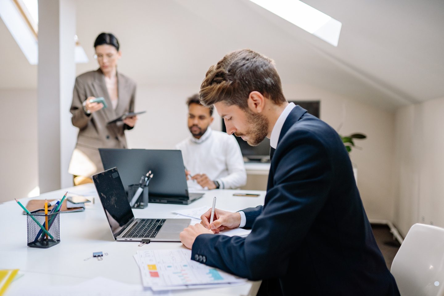 Business professionals reviewing reports and collaborating during a Phases of Project Management planning and execution meeting.