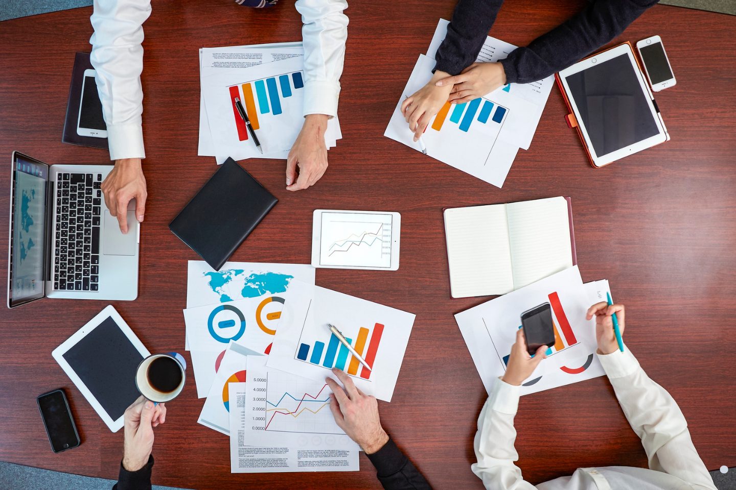 Process analysis team collaboration meeting with business professionals reviewing charts and performance reports.