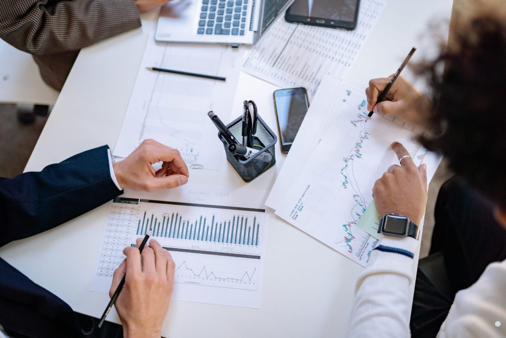 Team reviewing financial charts and discussing right and left skewed data distribution analysis in a business meeting.