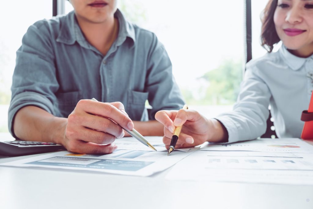ALT text showing professionals reviewing reports and discussing Six Sigma Define Phase project requirements and business metrics.