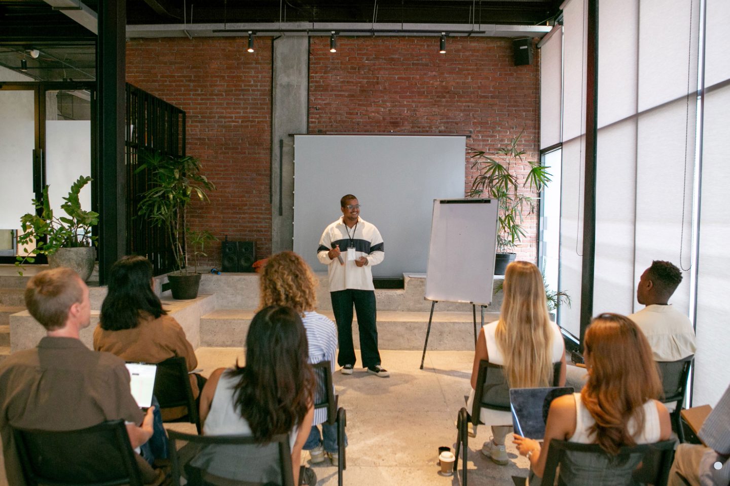 Presenter conducting an interactive Six Sigma Green Belt Training workshop with participants in a modern classroom setting.