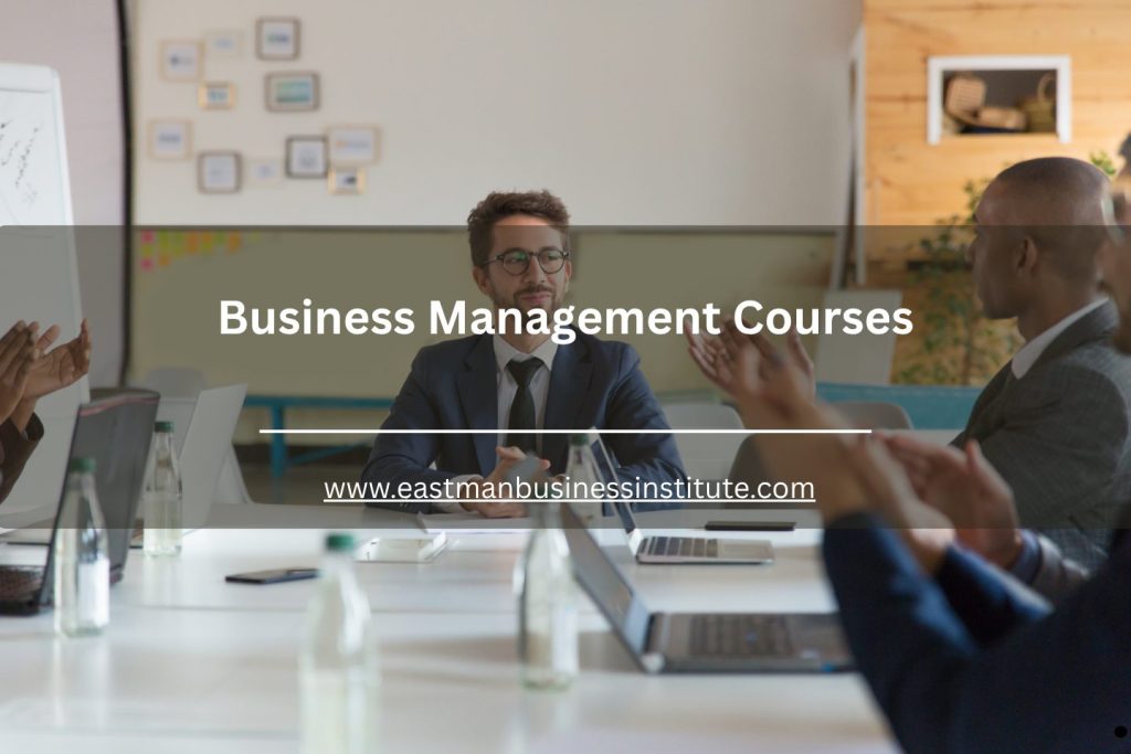 Executives attending a business management course seminar with laptops and presentations in a modern conference room.