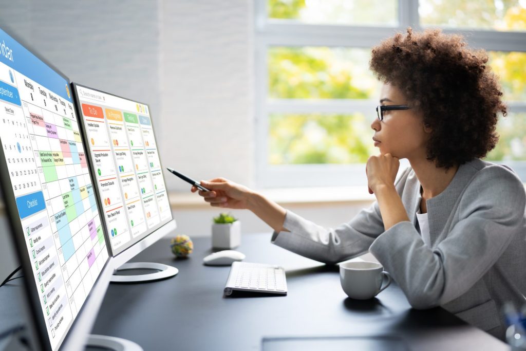 Professional analyzing a digital Kanban dashboard to manage workflow and project priorities.