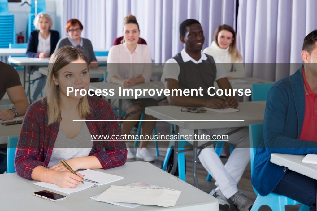 Classroom of learners engaged in a process improvement course, listening and taking notes.