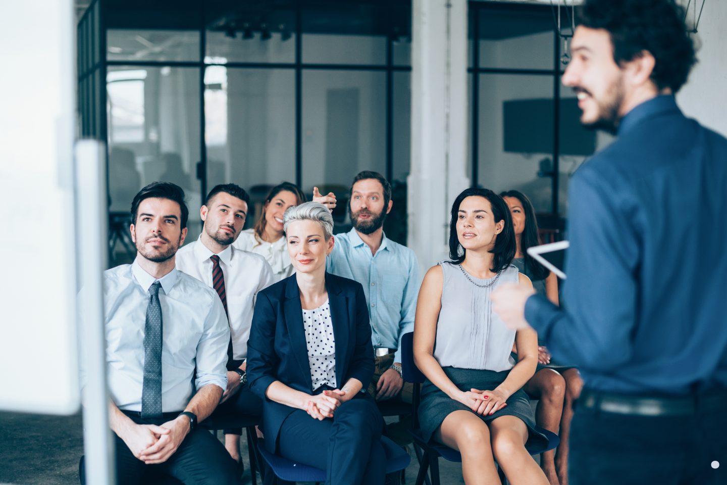 Group of professionals attending a training session and listening attentively to a presenter