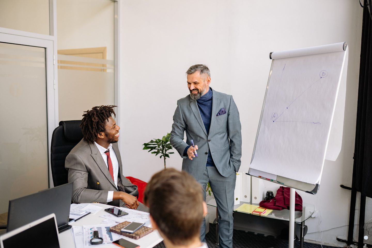 Business trainer presenting ideas on a flip chart to a colleague during a collaborative meeting