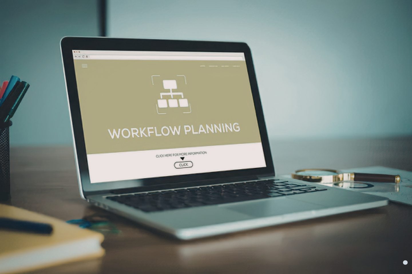 Laptop on a desk displaying a workflow planning interface with icons and navigation elements.