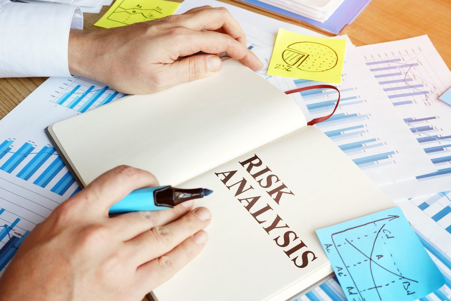 Business professionals examining risk analysis notes, charts, and financial planning documents during a strategy session.