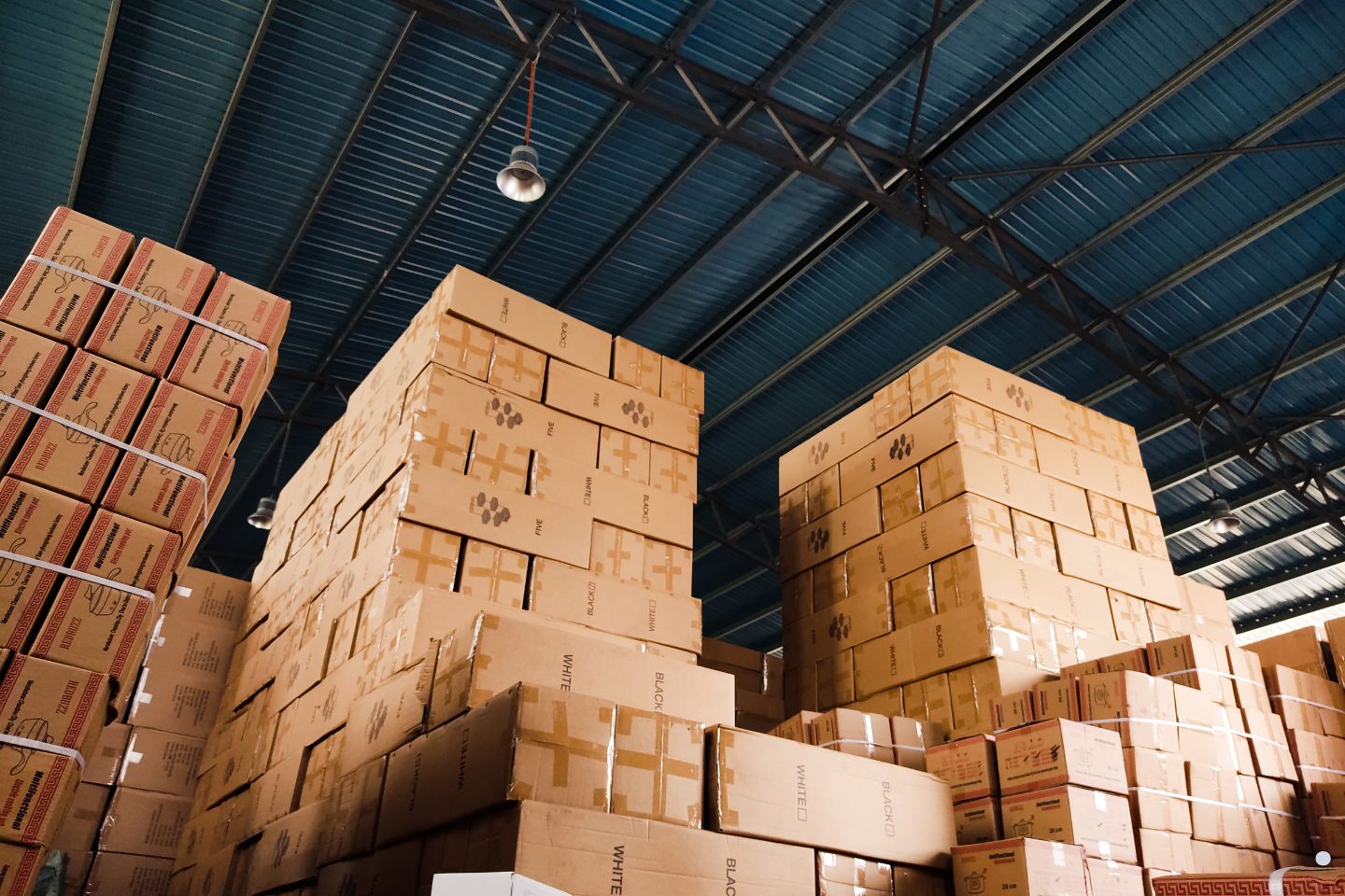 Supply chain capacity planning storage facility with stacked shipping boxes and bulk inventory organization.